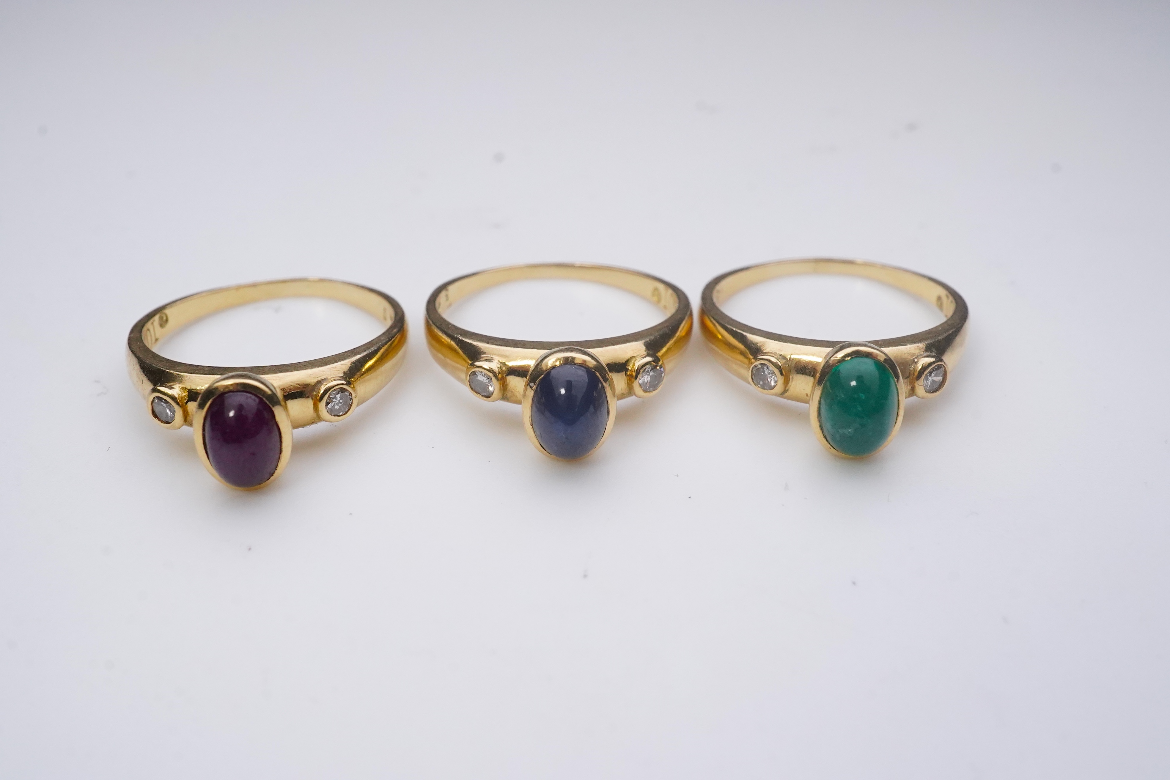 A suite of three gold and gem-set rings